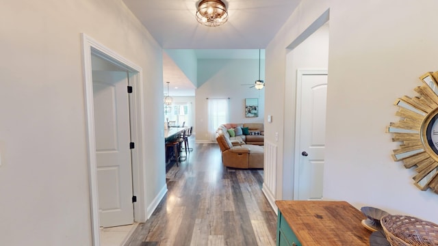 hall with baseboards and wood finished floors