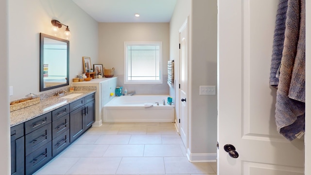 full bathroom with a garden tub, tile patterned flooring, baseboards, and vanity