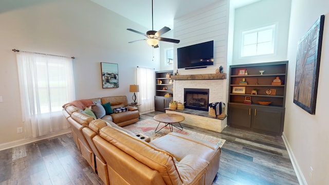 living area featuring high vaulted ceiling, a fireplace, wood finished floors, and baseboards