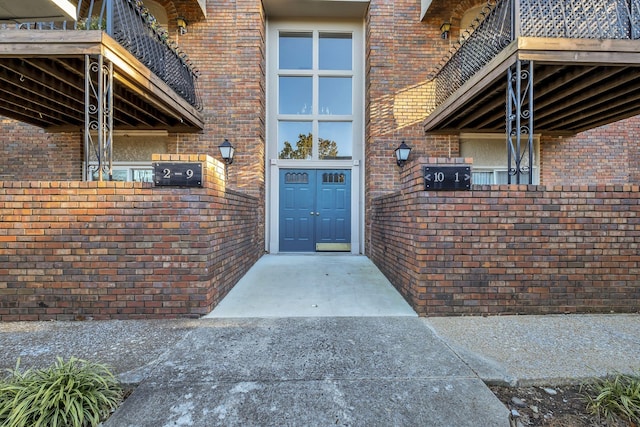 view of exterior entry with a balcony