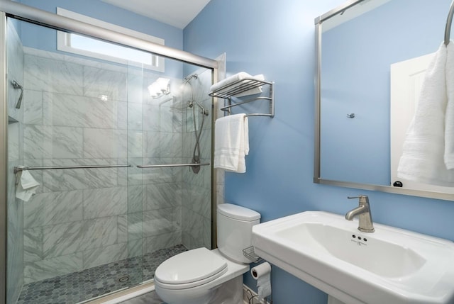 bathroom with sink, an enclosed shower, and toilet