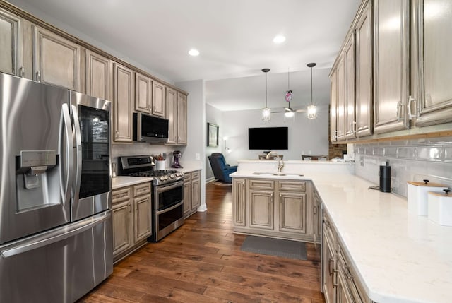 kitchen featuring sink, dark hardwood / wood-style floors, backsplash, pendant lighting, and appliances with stainless steel finishes