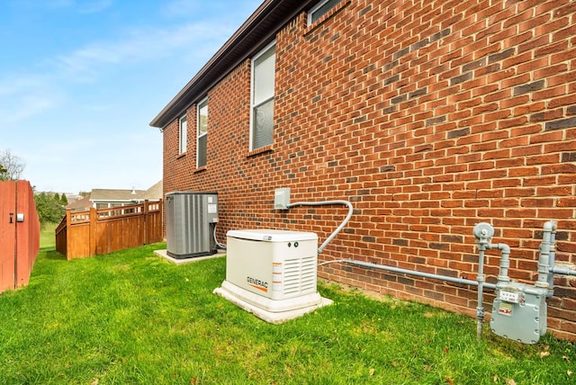 rear view of property featuring central air condition unit and a yard