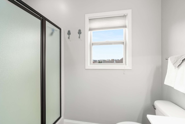 bathroom with toilet and an enclosed shower