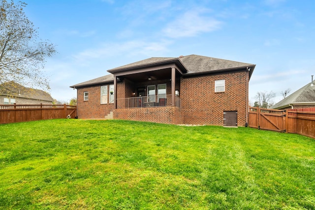 back of house with a lawn and ceiling fan