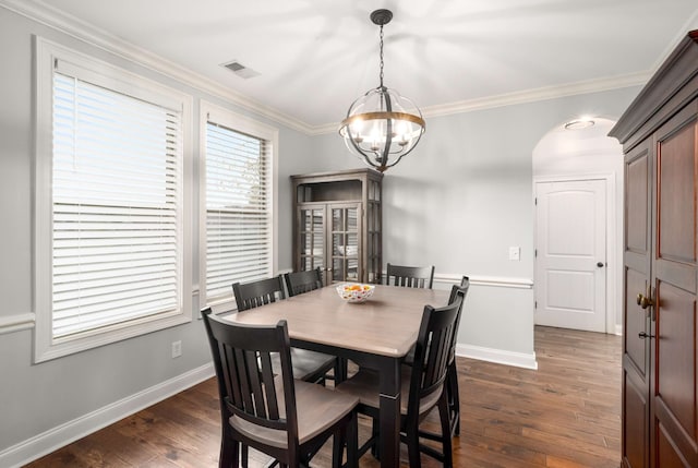 dining room featuring a chandelier, crown molding, and dark wood-type flooring