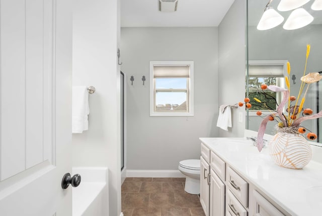 bathroom with vanity, toilet, a shower with door, and a wealth of natural light