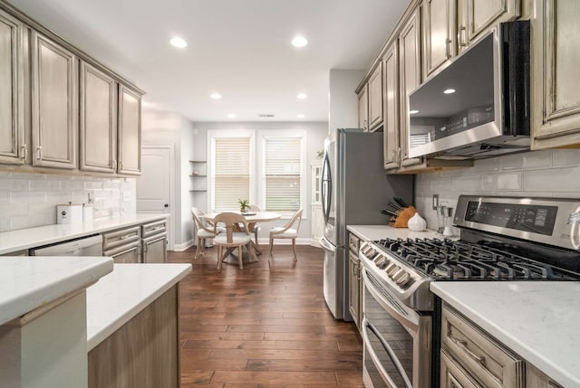 kitchen featuring decorative backsplash, dark hardwood / wood-style flooring, light stone countertops, and appliances with stainless steel finishes