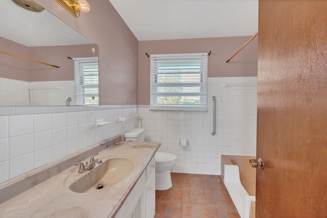 full bathroom featuring vanity, plenty of natural light, and tile walls