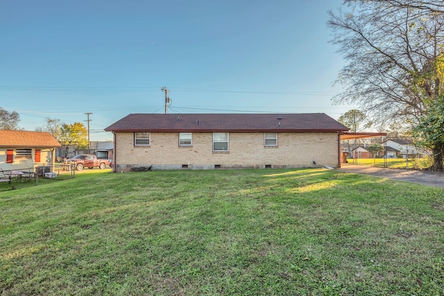 back of property with a yard and a carport