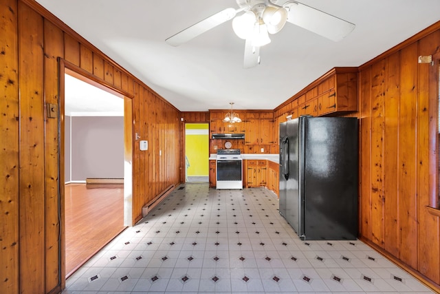 kitchen featuring black fridge, ornamental molding, white range oven, wooden walls, and pendant lighting