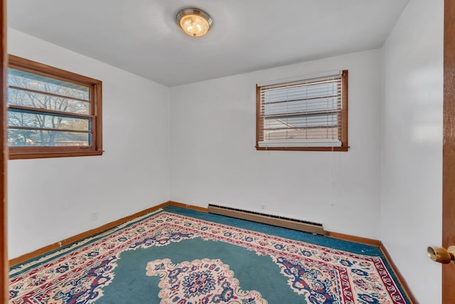 unfurnished room with a baseboard heating unit