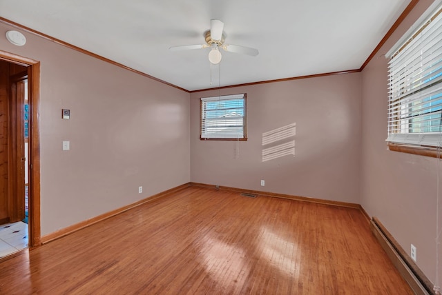 spare room with ceiling fan, plenty of natural light, light hardwood / wood-style floors, and a baseboard heating unit