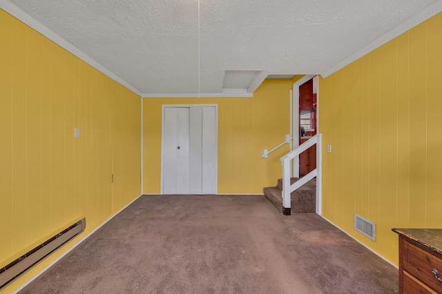 carpeted spare room featuring wooden walls, crown molding, a textured ceiling, and a baseboard heating unit