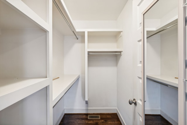 walk in closet with dark hardwood / wood-style flooring