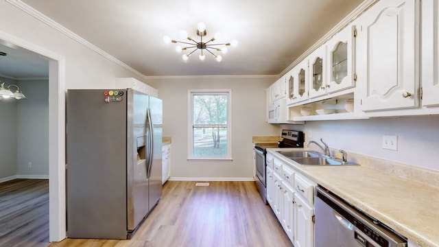 kitchen featuring a chandelier, stainless steel appliances, white cabinetry, and sink