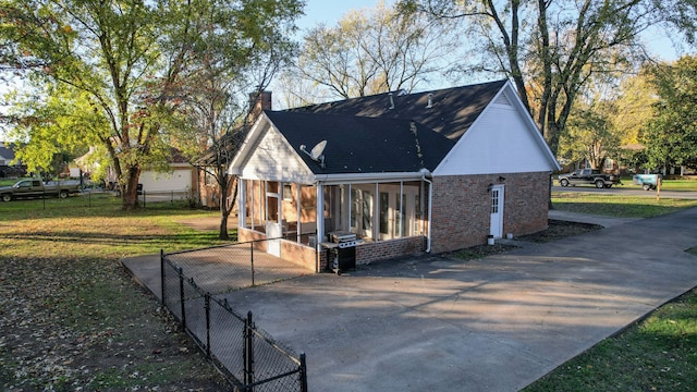 exterior space with a sunroom and a lawn