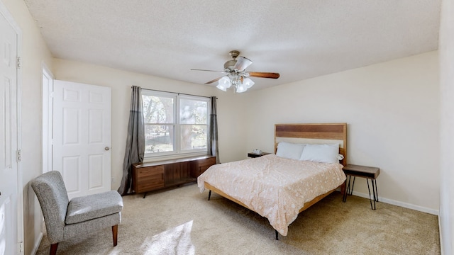 carpeted bedroom featuring ceiling fan and a textured ceiling