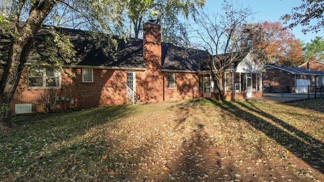 back of property featuring a sunroom and a yard