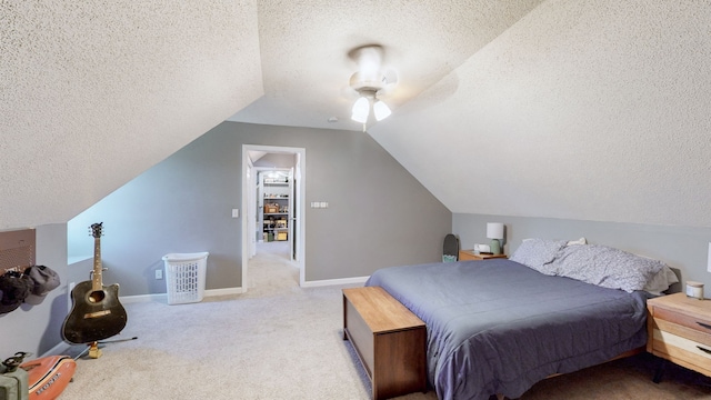 carpeted bedroom featuring ceiling fan, a textured ceiling, and vaulted ceiling