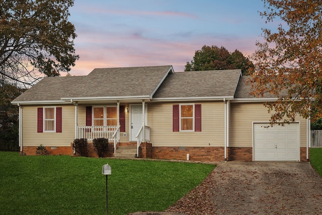 single story home with covered porch, a yard, and a garage