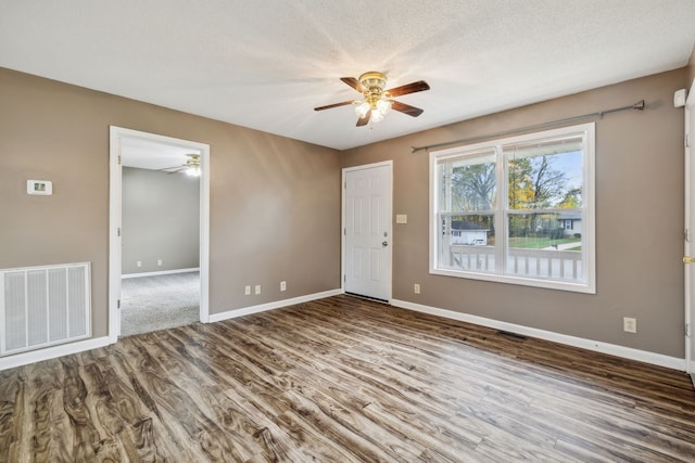 empty room featuring a textured ceiling and hardwood / wood-style flooring