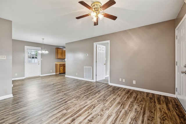 unfurnished living room with wood-type flooring and ceiling fan with notable chandelier