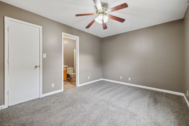 unfurnished bedroom with carpet, ensuite bathroom, and ceiling fan