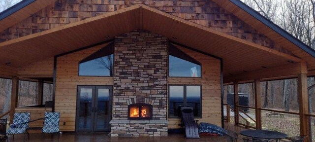 exterior space with an outdoor stone fireplace and french doors