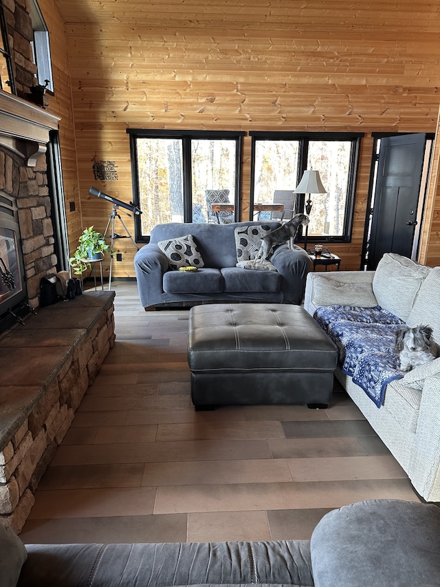 living room with wood walls, wood-type flooring, a fireplace, and wood ceiling