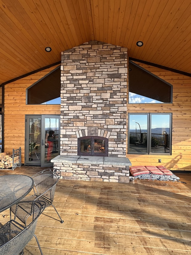 wooden deck with an outdoor stone fireplace