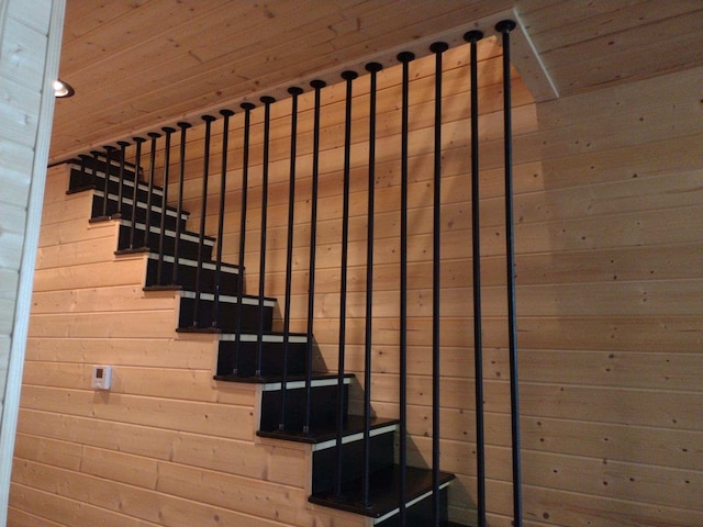 stairs featuring wood walls