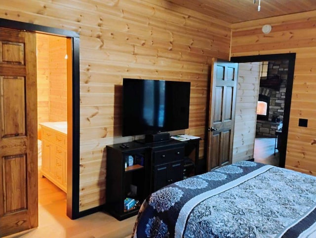 bedroom with light hardwood / wood-style floors, wood ceiling, and wooden walls