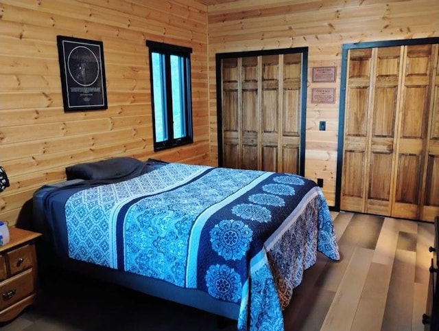 bedroom featuring wood-type flooring and wooden walls