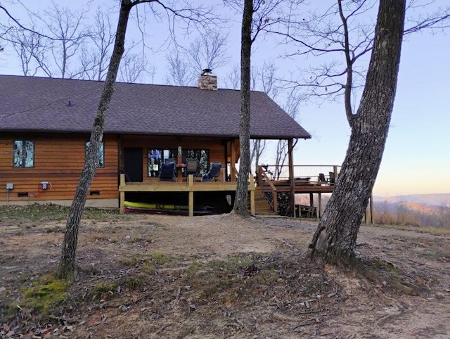 back house at dusk with a wooden deck