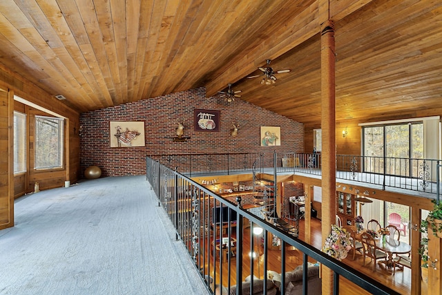 corridor featuring carpet, vaulted ceiling with beams, wooden ceiling, and brick wall