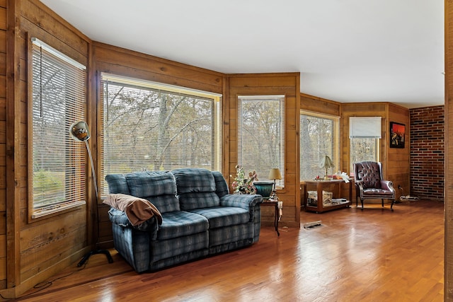 living room featuring wood-type flooring and wooden walls