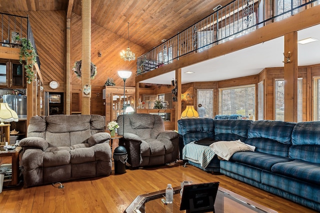 living room featuring hardwood / wood-style floors, high vaulted ceiling, wooden ceiling, and wood walls