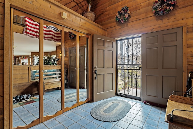 tiled foyer entrance featuring wood walls and wooden ceiling