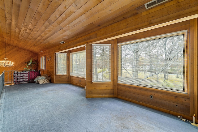 additional living space with wooden walls, carpet, lofted ceiling, and a notable chandelier