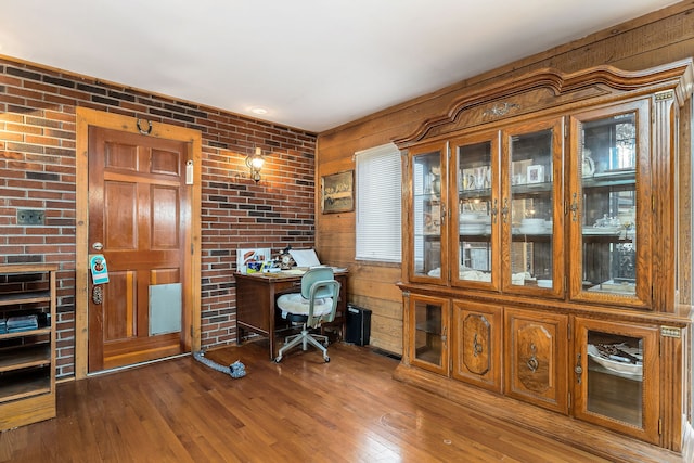 office featuring brick wall, dark hardwood / wood-style flooring, and wood walls