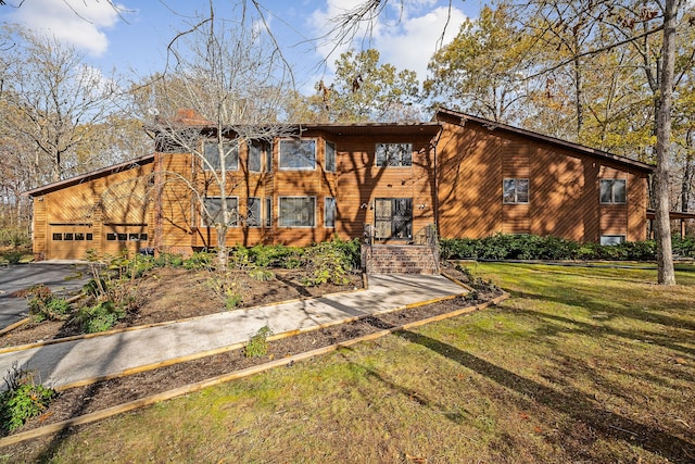 view of front of home with a front yard and a garage