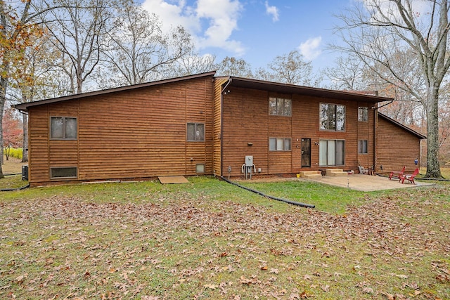 rear view of property featuring a lawn and a patio area