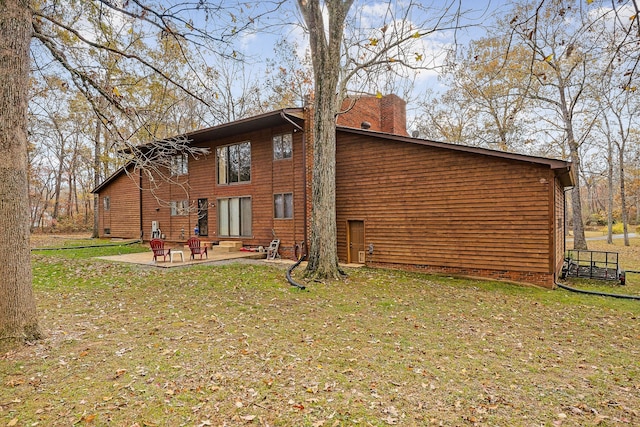 rear view of property featuring a patio area and a lawn