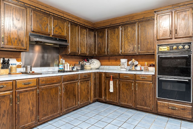 kitchen featuring light tile patterned floors and black double oven