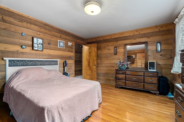 bedroom with light wood-type flooring and wooden walls