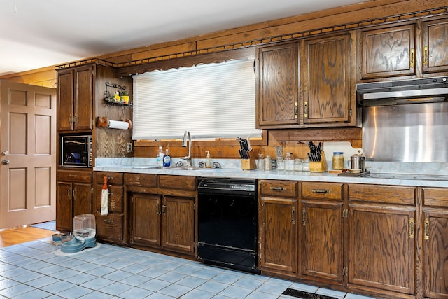 kitchen featuring sink, light tile patterned floors, and black dishwasher