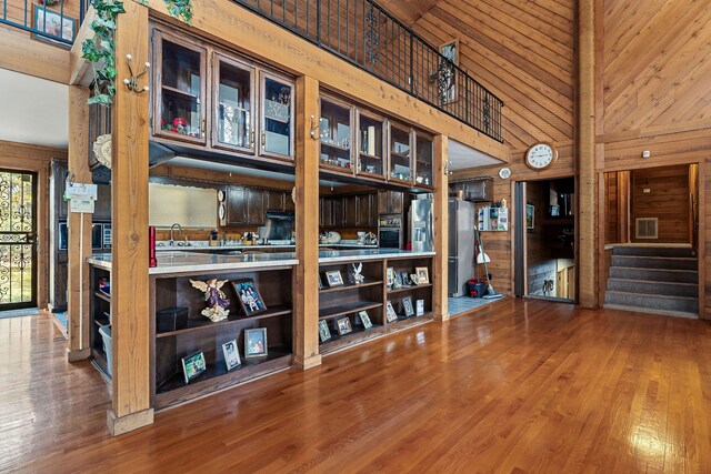 interior space with sink, hardwood / wood-style flooring, high vaulted ceiling, wooden ceiling, and wood walls