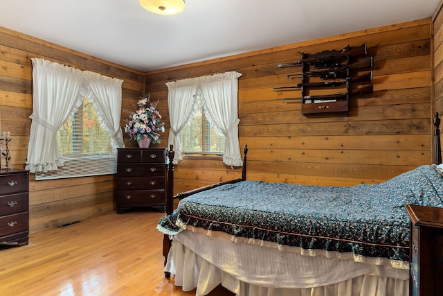 bedroom featuring hardwood / wood-style flooring and wood walls