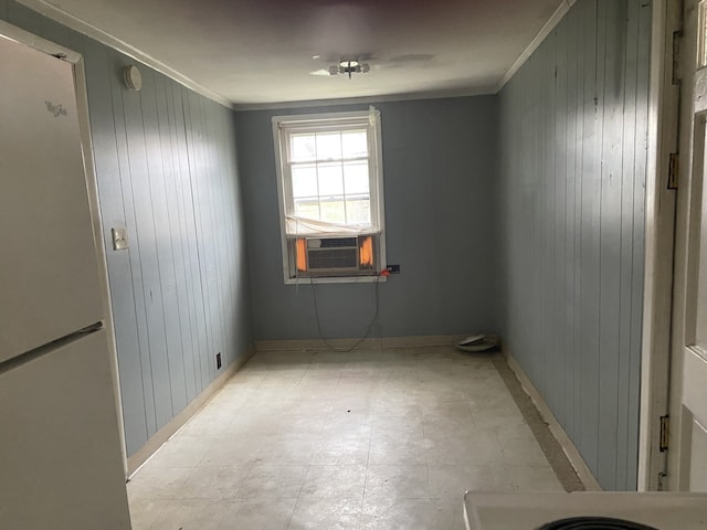 empty room featuring wood walls and ornamental molding